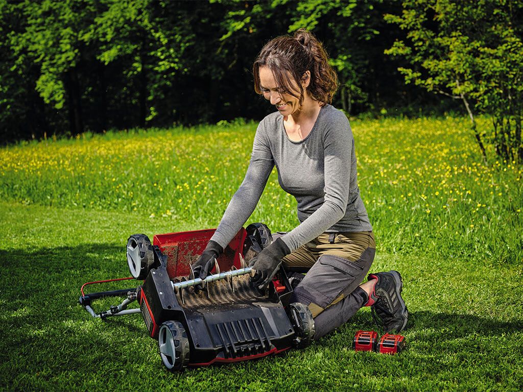 A woman changing the blade roller of her scarifier.