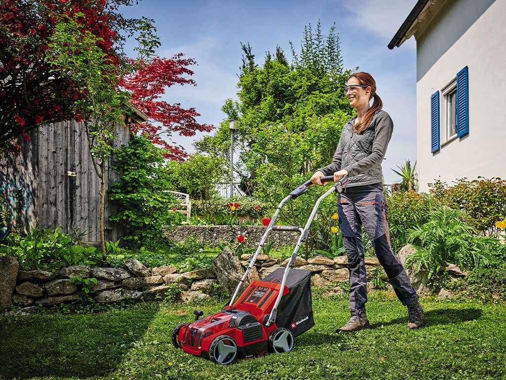 Woman scarifying lawn with battery-powered Einhell scarifier