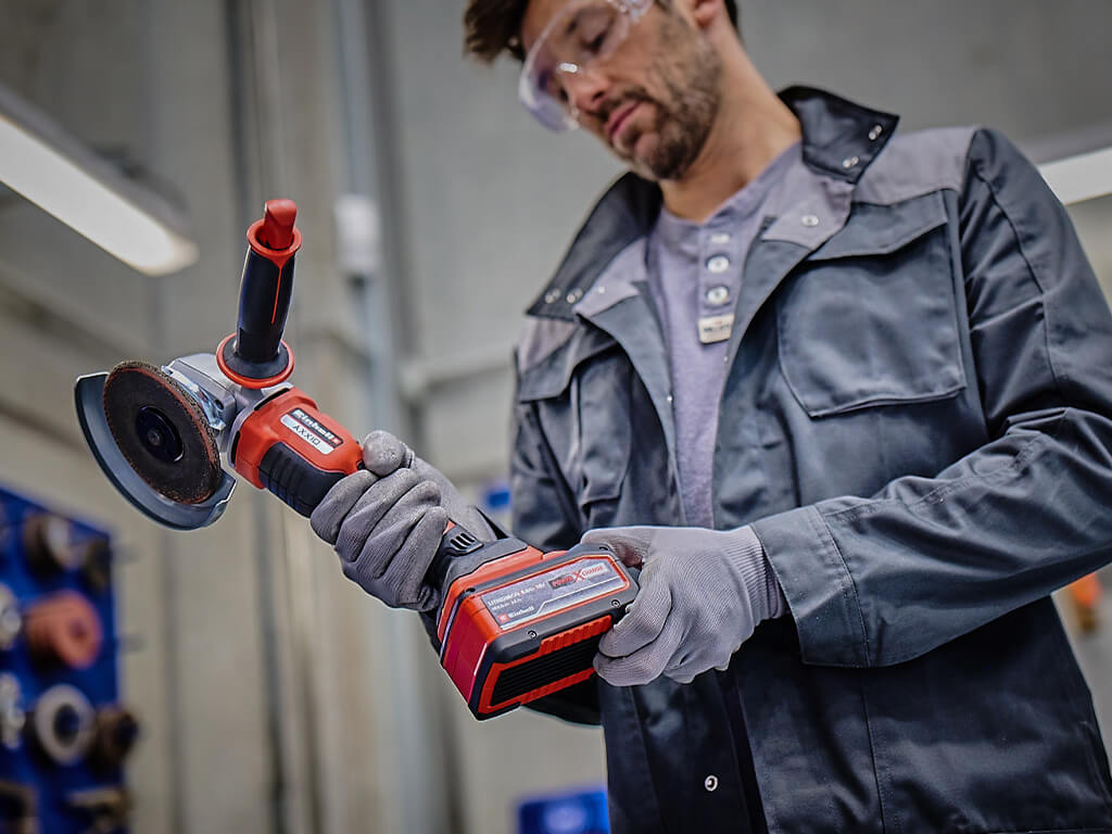 man puts battery into angle grinder