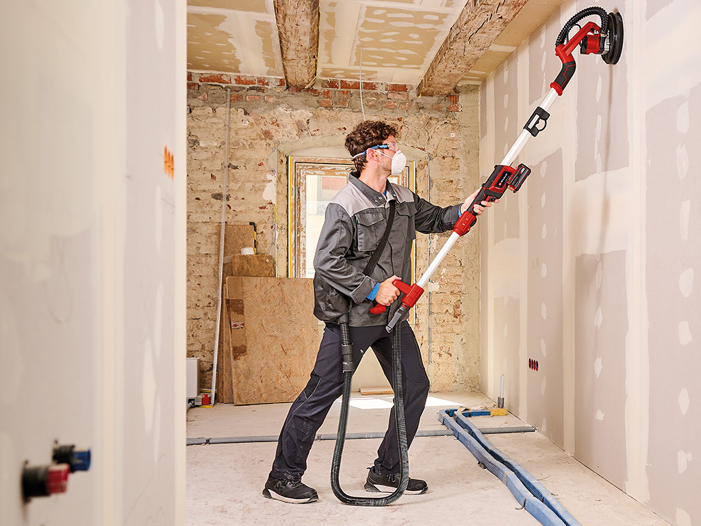 a man is sanding the wall