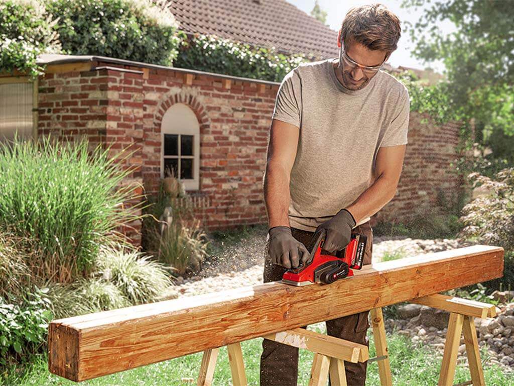 a man planes a wooden board