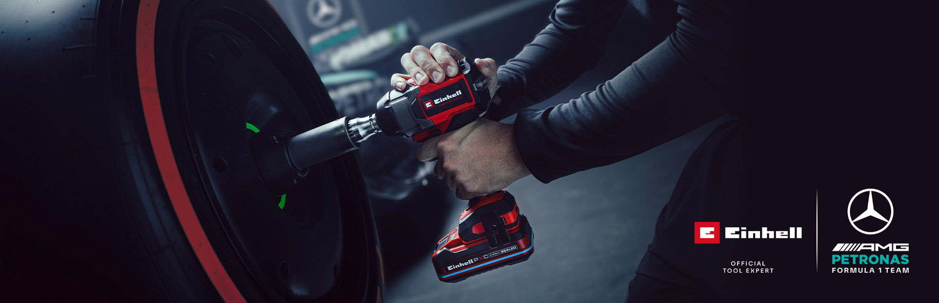 Akumulátorový rázový uťahovač Einhell pri použití na kolese automobilu, so značkou a logom partnerstva tímu Mercedes-AMG Petronas Formula One