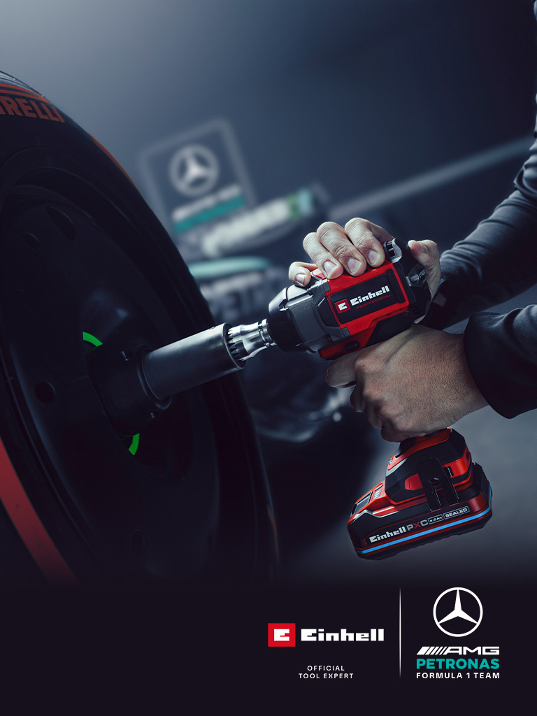 Akumulátorový rázový uťahovač Einhell pri použití na kolese automobilu, so značkou a logom partnerstva tímu Mercedes-AMG Petronas Formula One