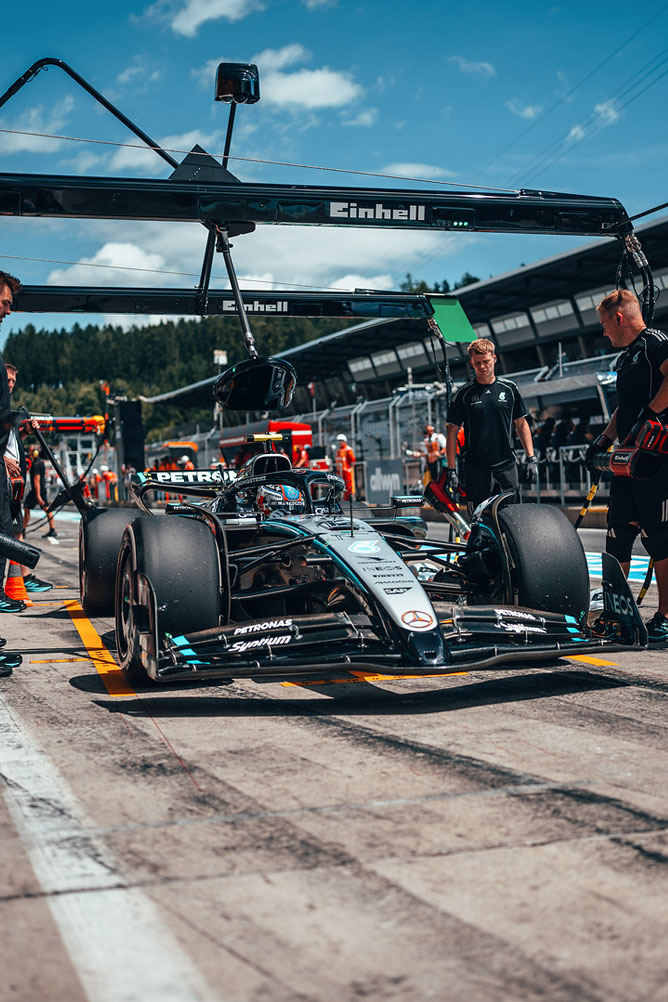 Mercedes-AMG Formula 1 auto je v boxoch, obklopené členmi tímu pod garážovou konštrukciou Einhell.