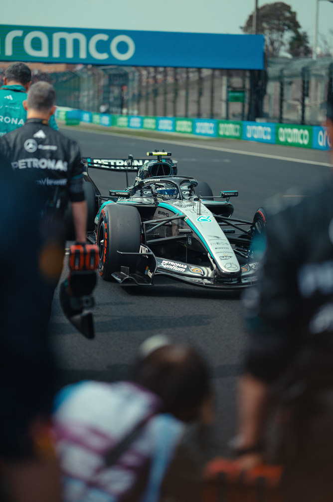 Mercedes F1 v boxovej uličke obklopené tímom