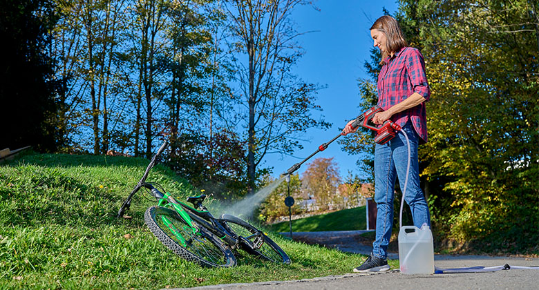 A man cleaning his bike with the Einhell high pressure cleaner